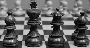 Primer plano de un tablero de ajedrez (visto desde el bando negro) antes de comenzar una partida