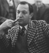 Koltanowski con una pipa en la mano derecha, pensativo, con una llamativa chaqueta a cuadros