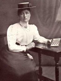 Foto de Edith Helen Baird, sentada con un tablero de ajedrez en la mano