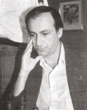 Juan Manuel Belln medita una jugada con una mano sosteniendo su cabeza. Fotografa correspondiente a unis 50 aos de edad
