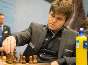 Magnus Carlsen realizando un movimiento con una botella de refresco a su lado